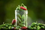 Glass Jar Overfull With Green And Red Jalapeanos