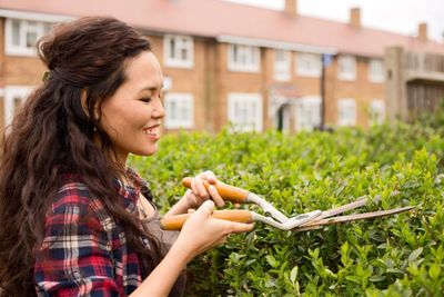 Woman Pruning Hedges