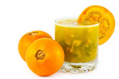 Jar Of Naranjilla Juice Next To Whole Naranjilla Fruits