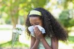 Child Sneezing Next To White Flowers