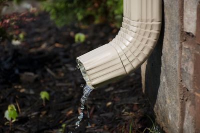 Water Pouring Out Of Gutter Into Soil