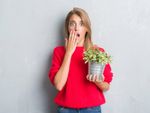 Woman With A Surprised Face Holding A Potted Plant