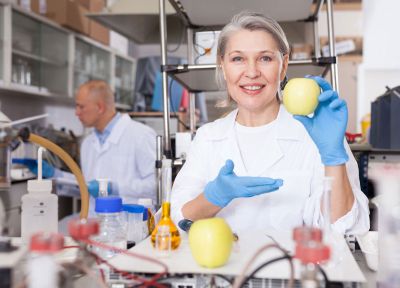 Chemist In A Laboratory Holding An Apple