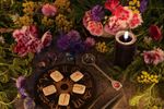 Flowers On A Table Next To A Zodiac Signs  A Candle  And Other Ritual Objects