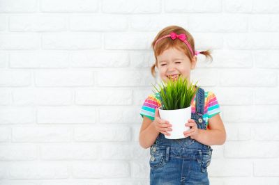Little Girl Holding Potted Plant Smiling