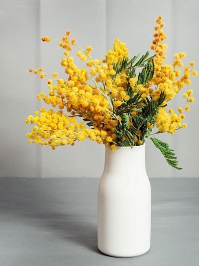 Bouquet Of Bright Yellow Flowers In White Glass Vase
