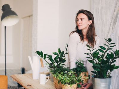 Woman Surrounded By Green Potted Indoor Plants