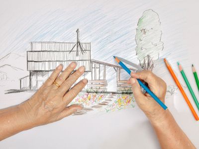 Hands Drawing A House And Garden Sketch