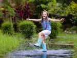 Child Playing In Water With Rain Boots