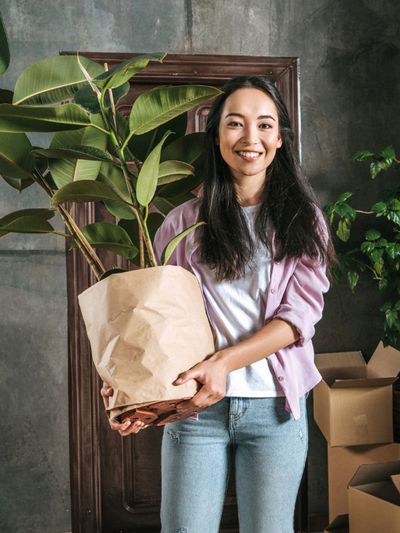 Person Holding A Large Potted Plant