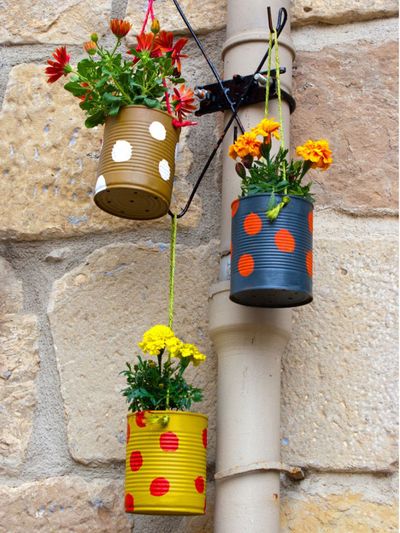 Three DIY Plant Containers Made Of Painted Tin Cans