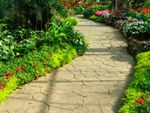 A Flagstone Path Lined With Colorful Flowers