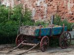 Old Wooden Cart Full Of Dry Hay Infront Of A Garden