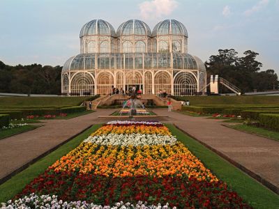 Brazilian Style Garden With Beautiful Flower Garden Infront Of A Large Greenhouse