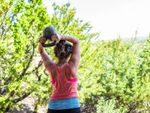 Woman Exercising Outdoors Near Green Plants