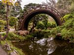 A Japanese Style Garden With A Bridge Over Water