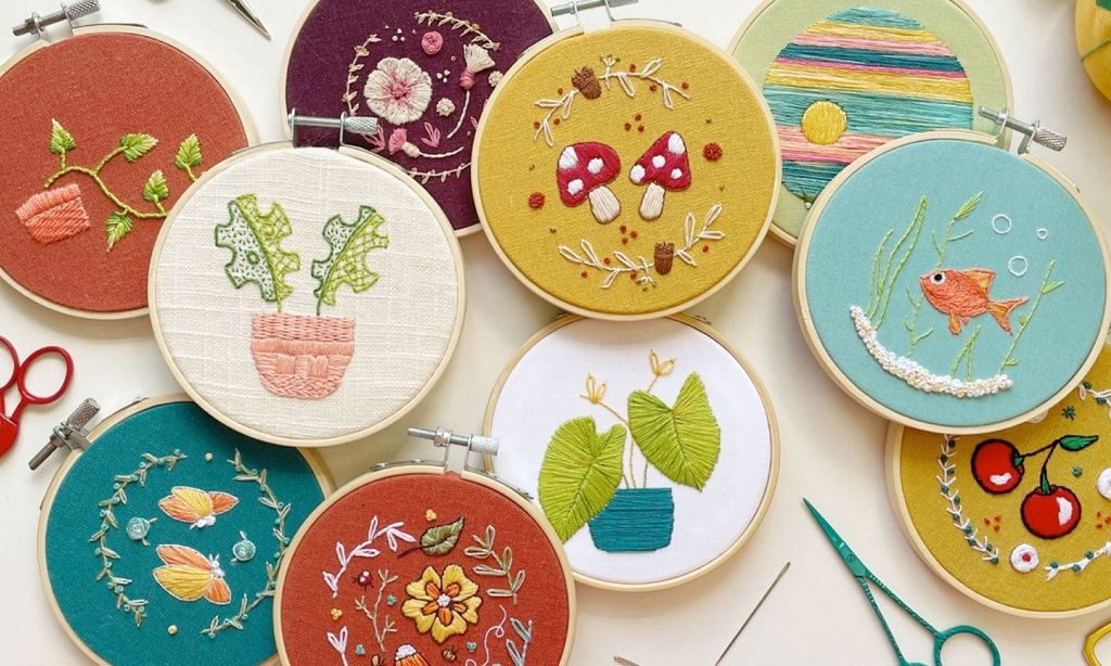 Seven different embroidery hoops with various embroidered designs