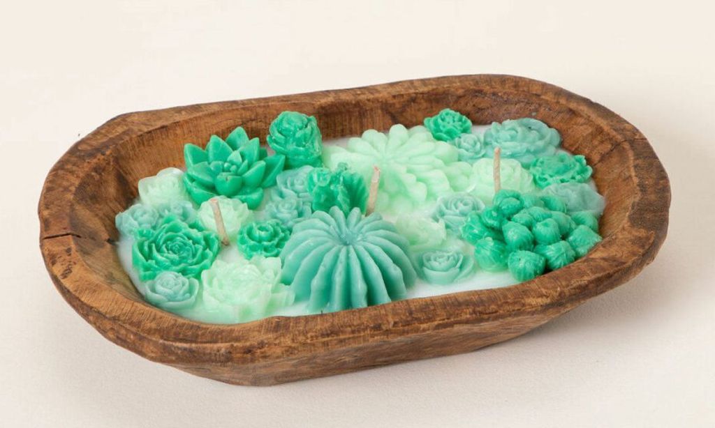 A wooden bowl with candle wax inside shaped like mini succulents