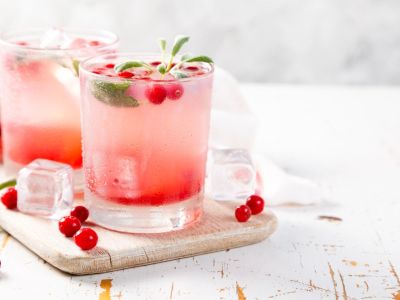 A refreshing pink cocktail with cranberries and sage leaves