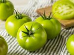 Close up of several green tomatoes on a striped towel