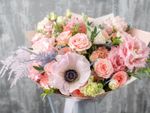 A beautiful bouquet of light pink flowers and foliage in a vase