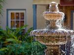A multi-tiered fountain in front of a house
