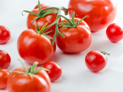 Bright red tomatoes on a white surface