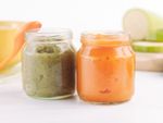 Two jars of pureed baby food, one orange and one green