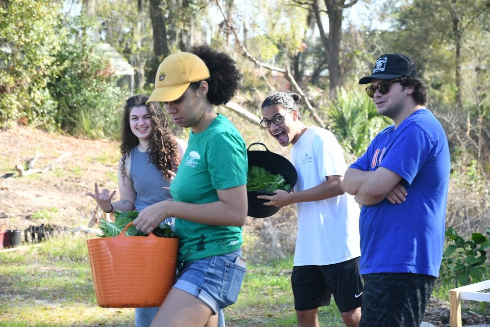 Young people carrying buckets in a garden