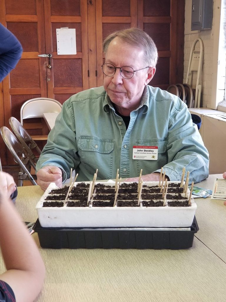 A man with a seed starting tray
